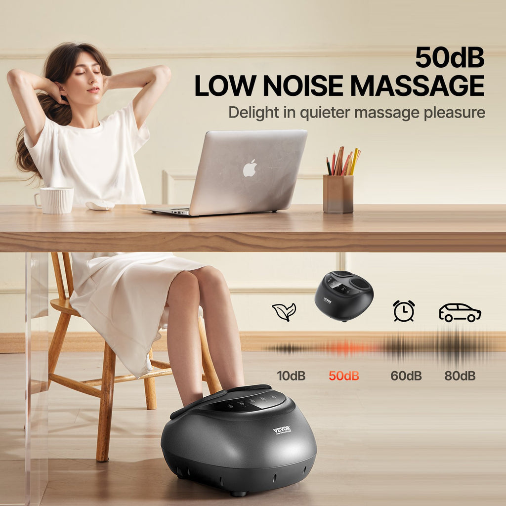 Black foot massager shown in use under a table with feet resting on the unit