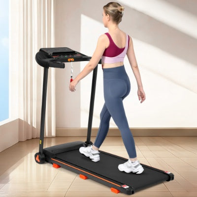 Black folding treadmill with orange accents, woman walking indoors on the running belt