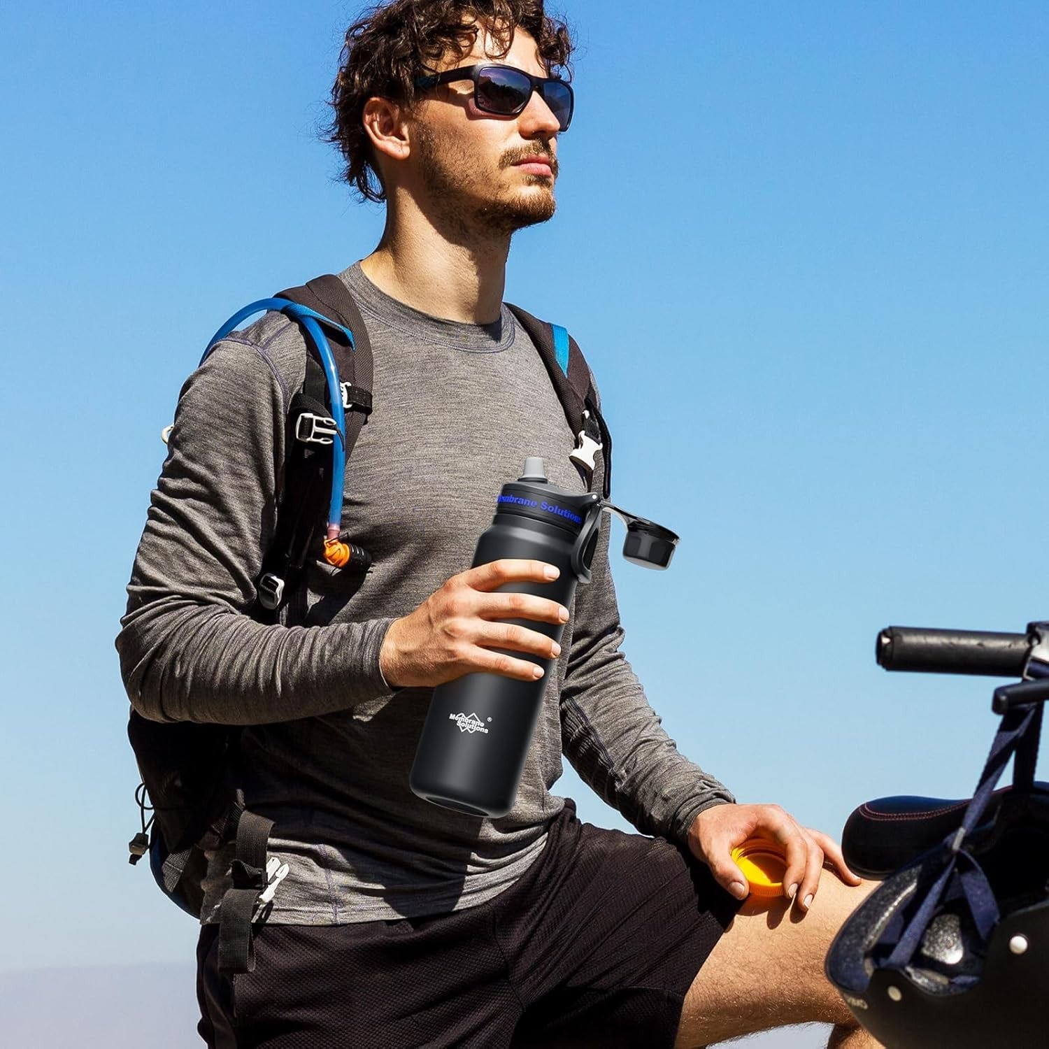 Black 32oz filtered water bottle held by a hiker outdoors