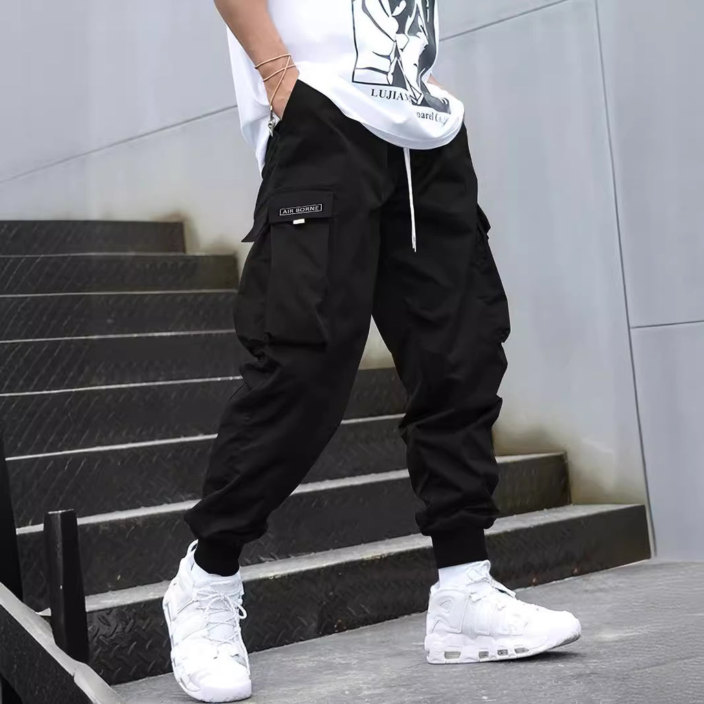 Black multi-pocket cargo pants with drawstring hem and side cargo flap pockets