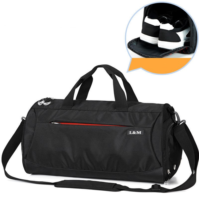 Black gym duffel bag with top handles, shoulder strap, and side shoe pocket with sneakers