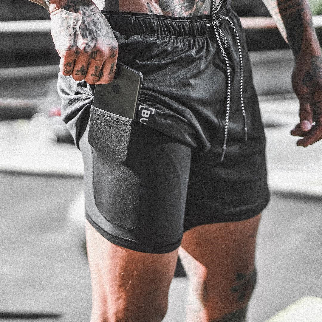 Black athletic shorts featuring side phone pocket, drawstring, and zip cord detail