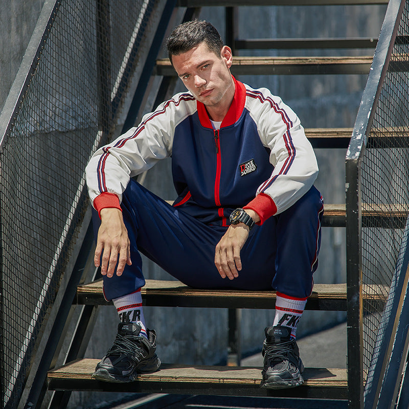 Navy zip tracksuit with white sleeves and red trim, paired with tapered joggers