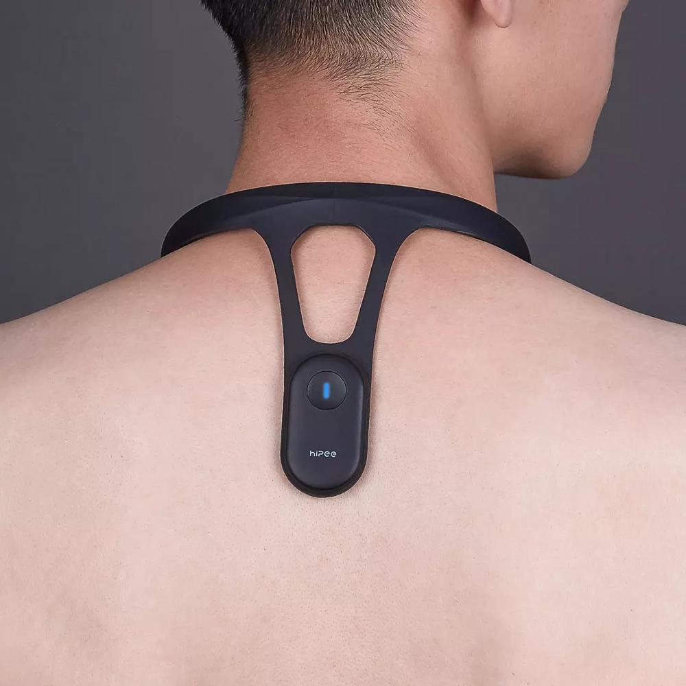 Black posture trainer sensor module centered on upper back with open Y-shaped band