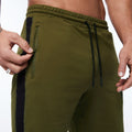 Olive green running shorts with black side stripe, zip pocket, and drawstring