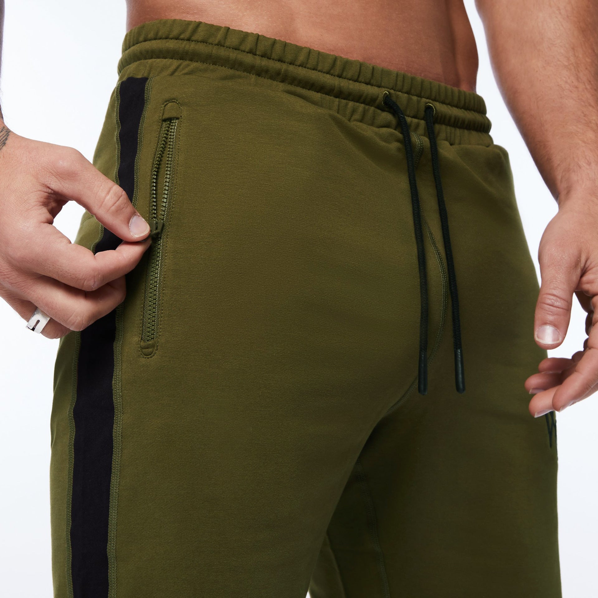 Olive green running shorts with black side stripe, zip pocket, and drawstring