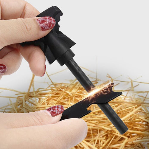 Black fire starter tool igniting sparks on dry tinder in a hand