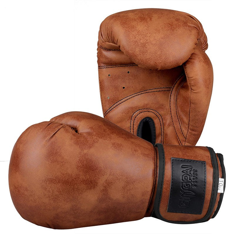 Tan-brown vintage boxing gloves with black wrist strap, one glove raised and other curled