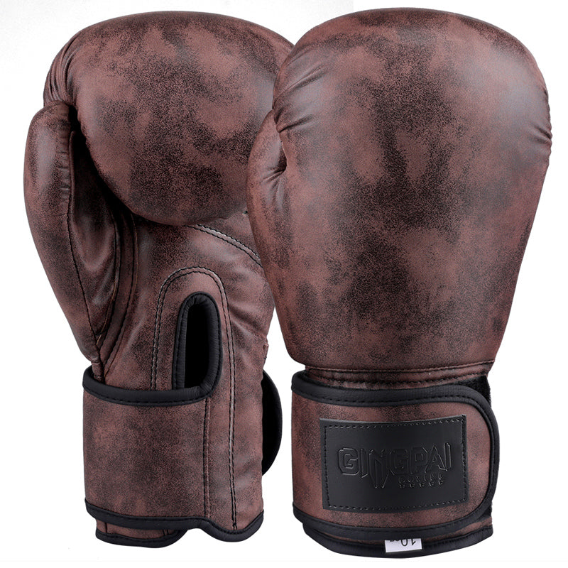 Dark brown vintage boxing gloves with black wrist strap and padded knuckle, pair front