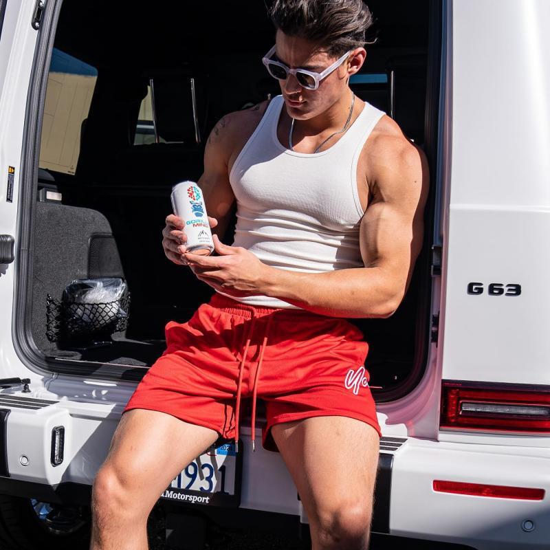 Red quick-dry training shorts with elastic waistband and drawstring, side logo detail.