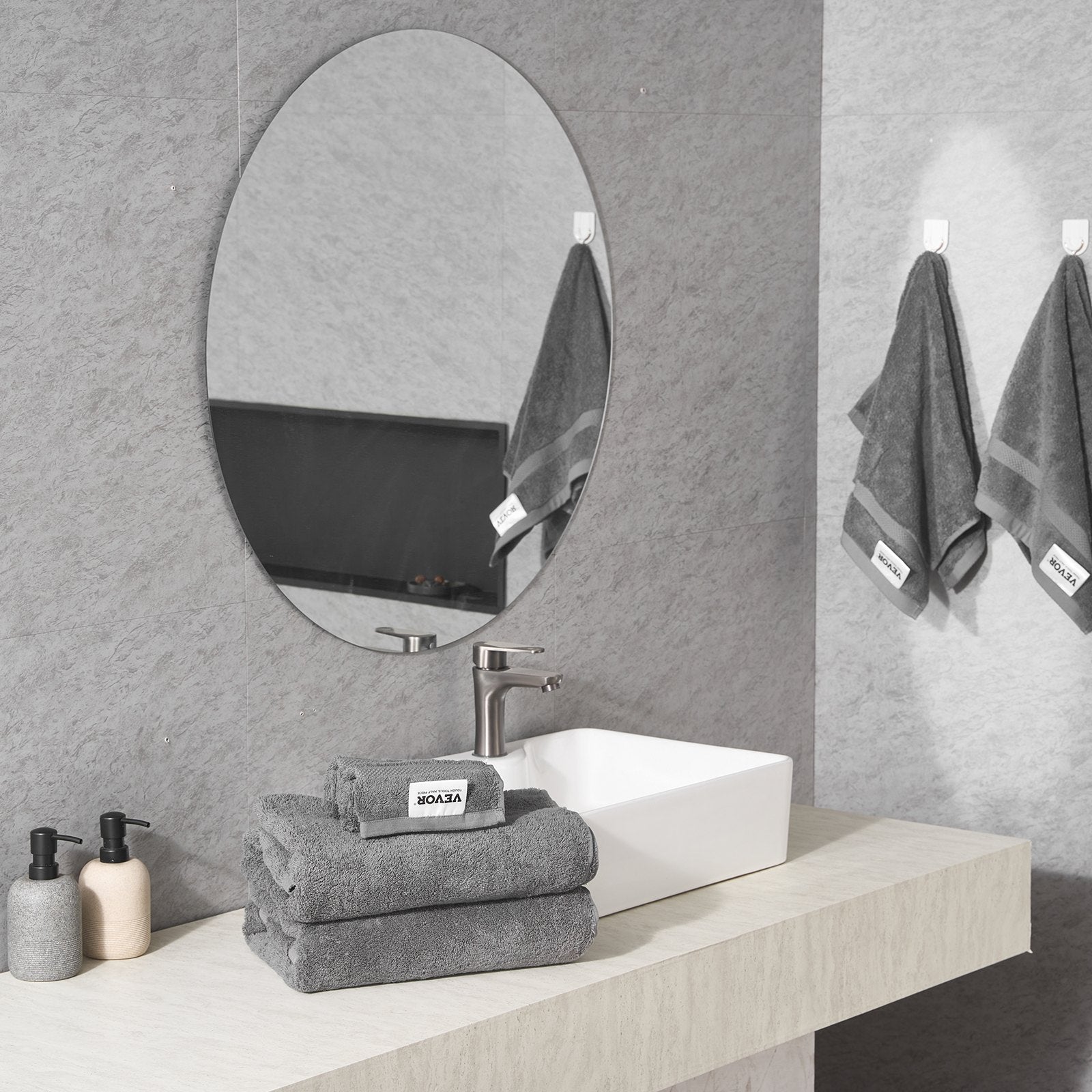 Grey towel set with a folded towel and two hanging towels, plush terry texture