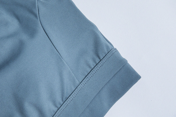 High-support sports bra fabric close-up in muted blue, stitched seam details