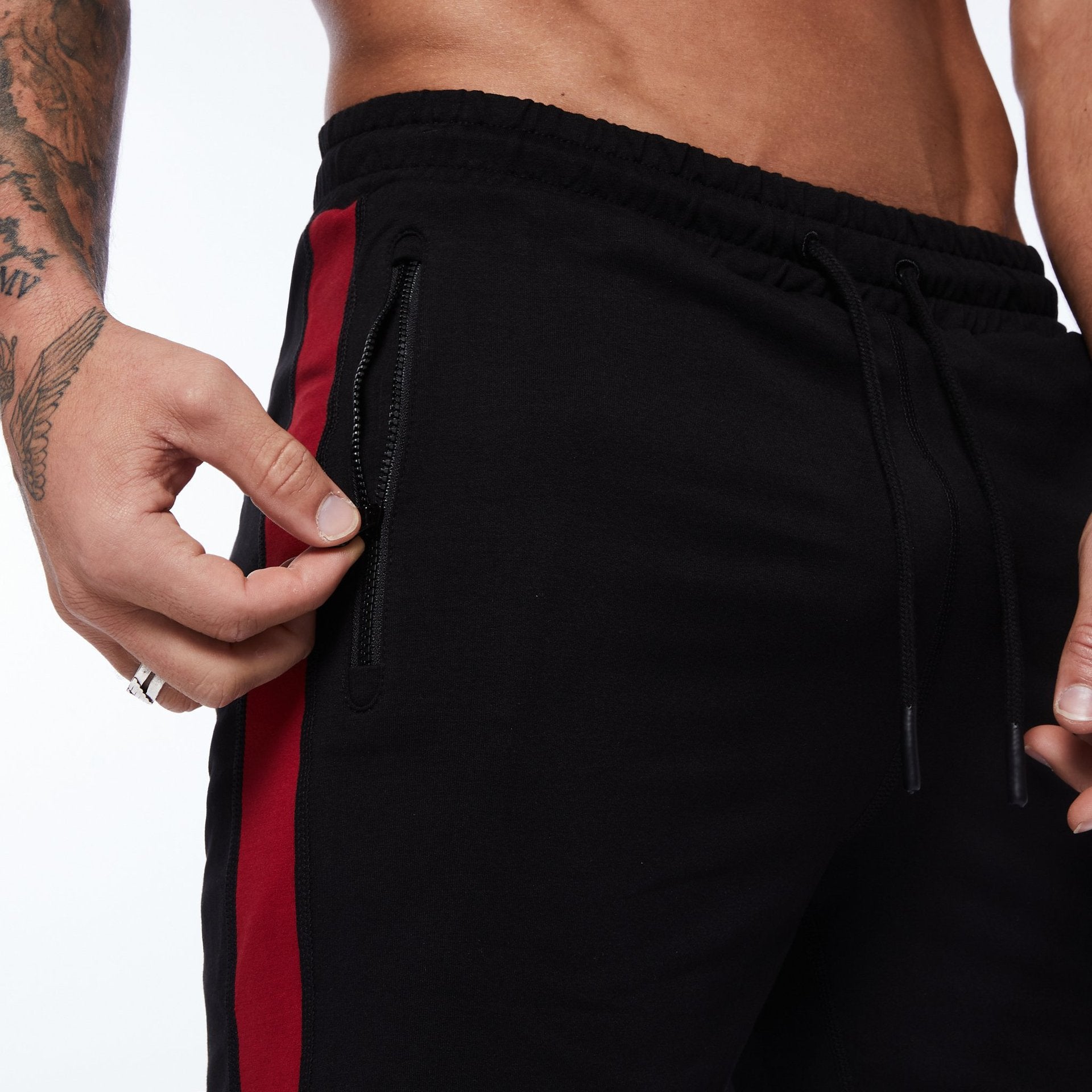 Black running shorts with red side stripe, zip pocket, and drawstring