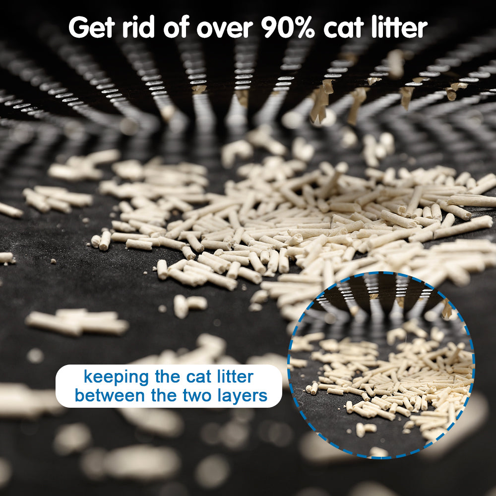 Black textured cat litter mat with scattered litter pieces on the surface