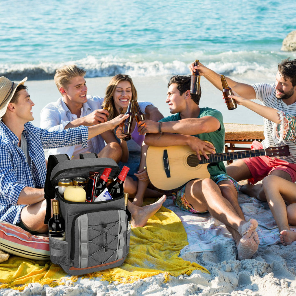 Grey insulated cooler backpack with bottle pocket and front zipper, at outdoor picnic