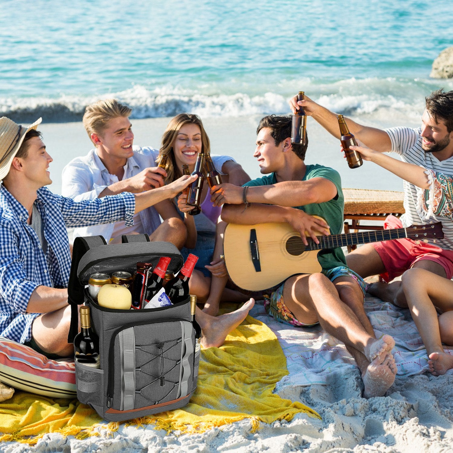 Grey insulated cooler backpack with bottle pocket and front zipper, at outdoor picnic