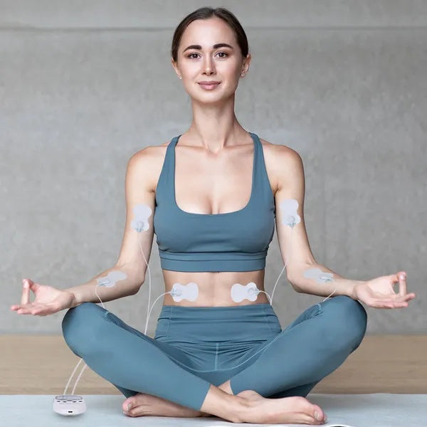 Person seated with dual-channel TENS electrode pads on arms and chest area