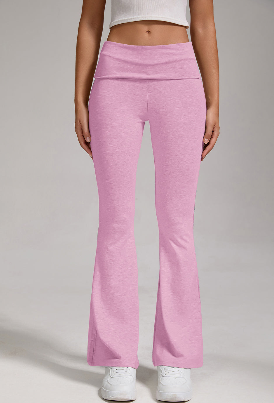 Mauve-pink flare leggings with fold-over high-rise waist and wide bell bottoms, front view