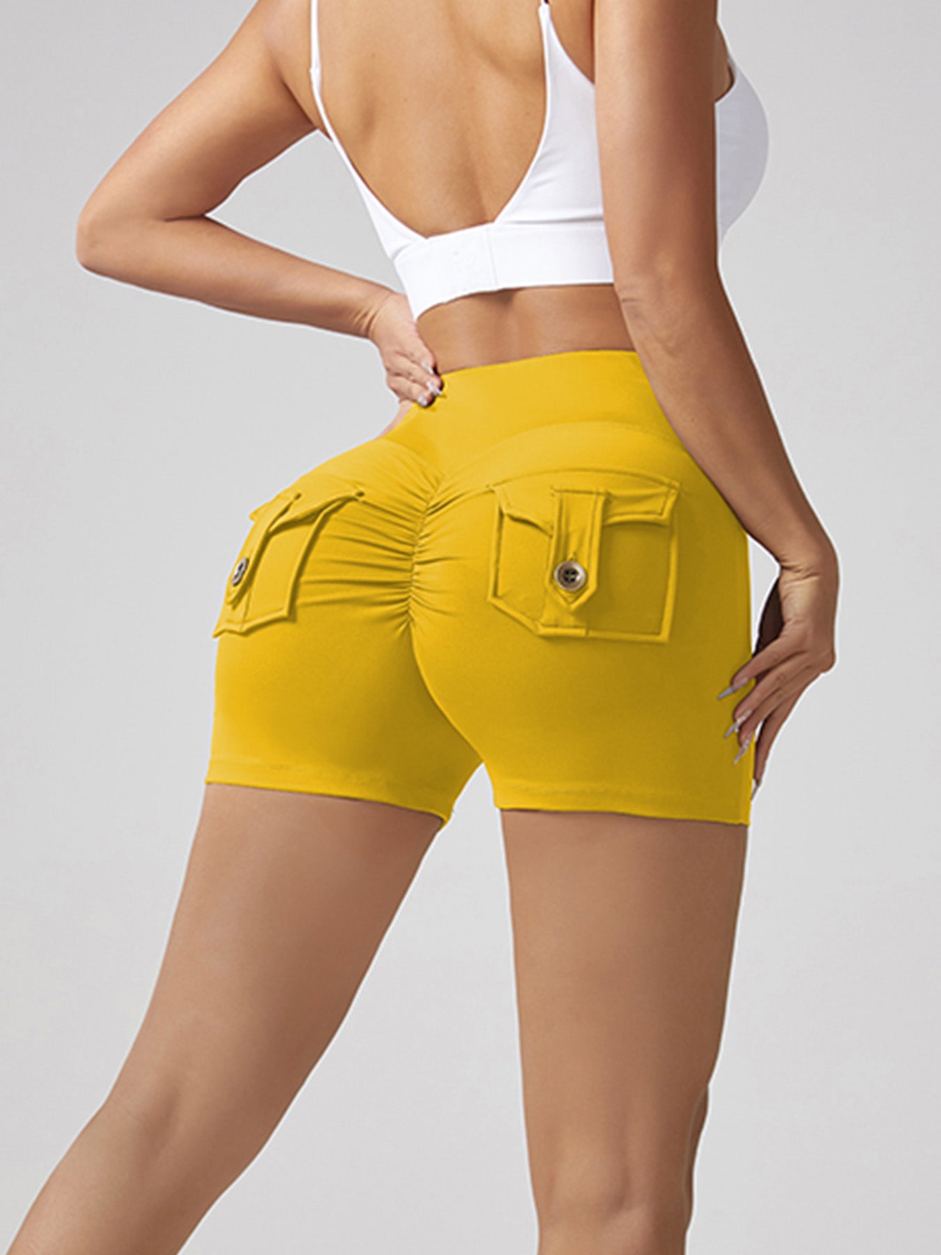 Yellow running shorts with back pocket tab and small gold button detail