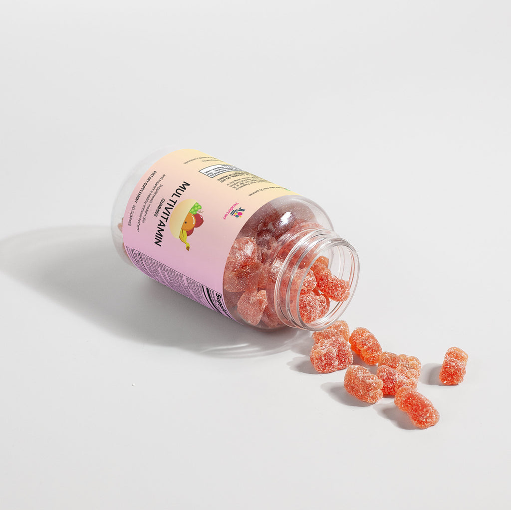 Multivitamin gummies bottle on side with dark label and red bear gummies spilled