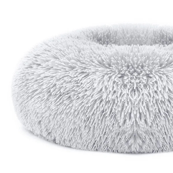 Light gray shag fleece oval pet bed with cushioned raised center