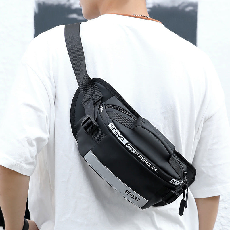Black crossbody waist bag side view with zip pocket, contrast trim, and buckle strap