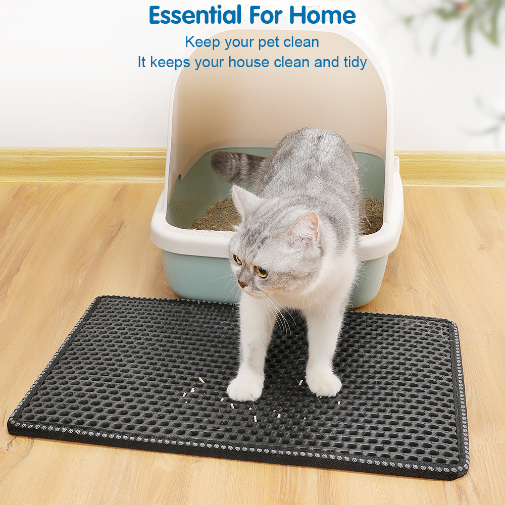 Black cat litter mat with hexagonal texture under a cat in front of a litter box