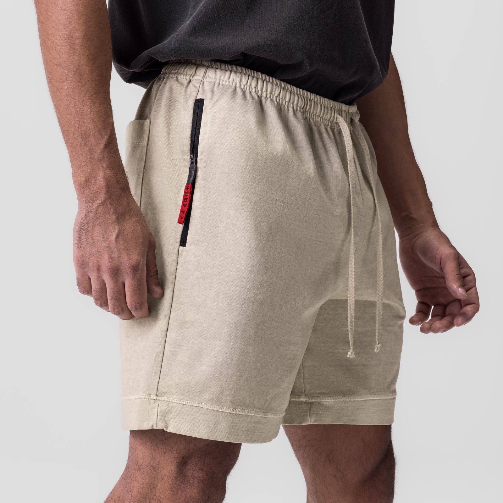 Beige quick-dry gym shorts with elastic waistband, drawstring, and side zip pocket