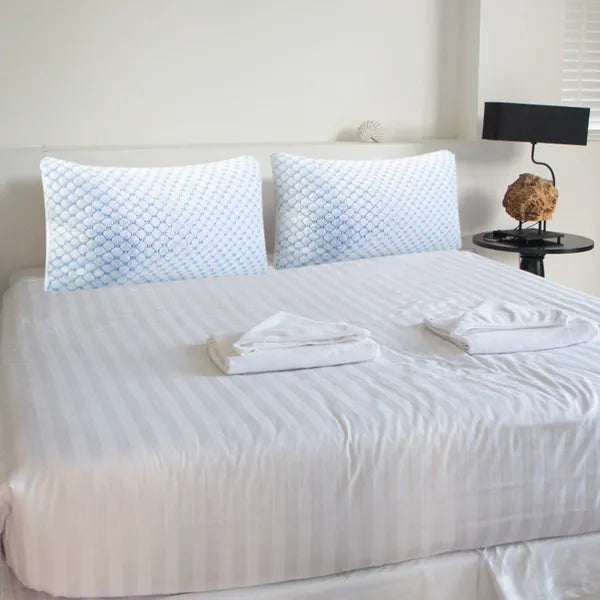 Cooling gel memory foam pillows with blue hex-pattern covers on bed surface