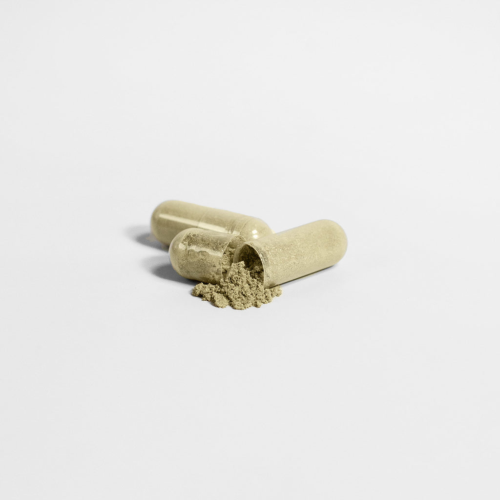 Beige softgel capsules spilled in front of a blank background