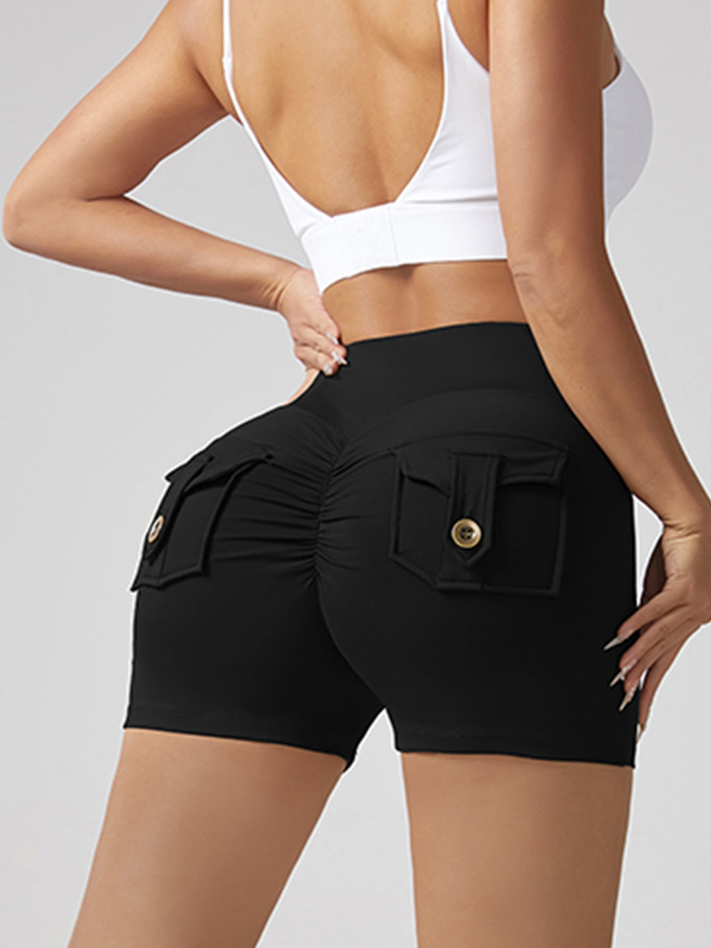 Black running shorts with back pocket tab and gold button, ruched hip-lifting style