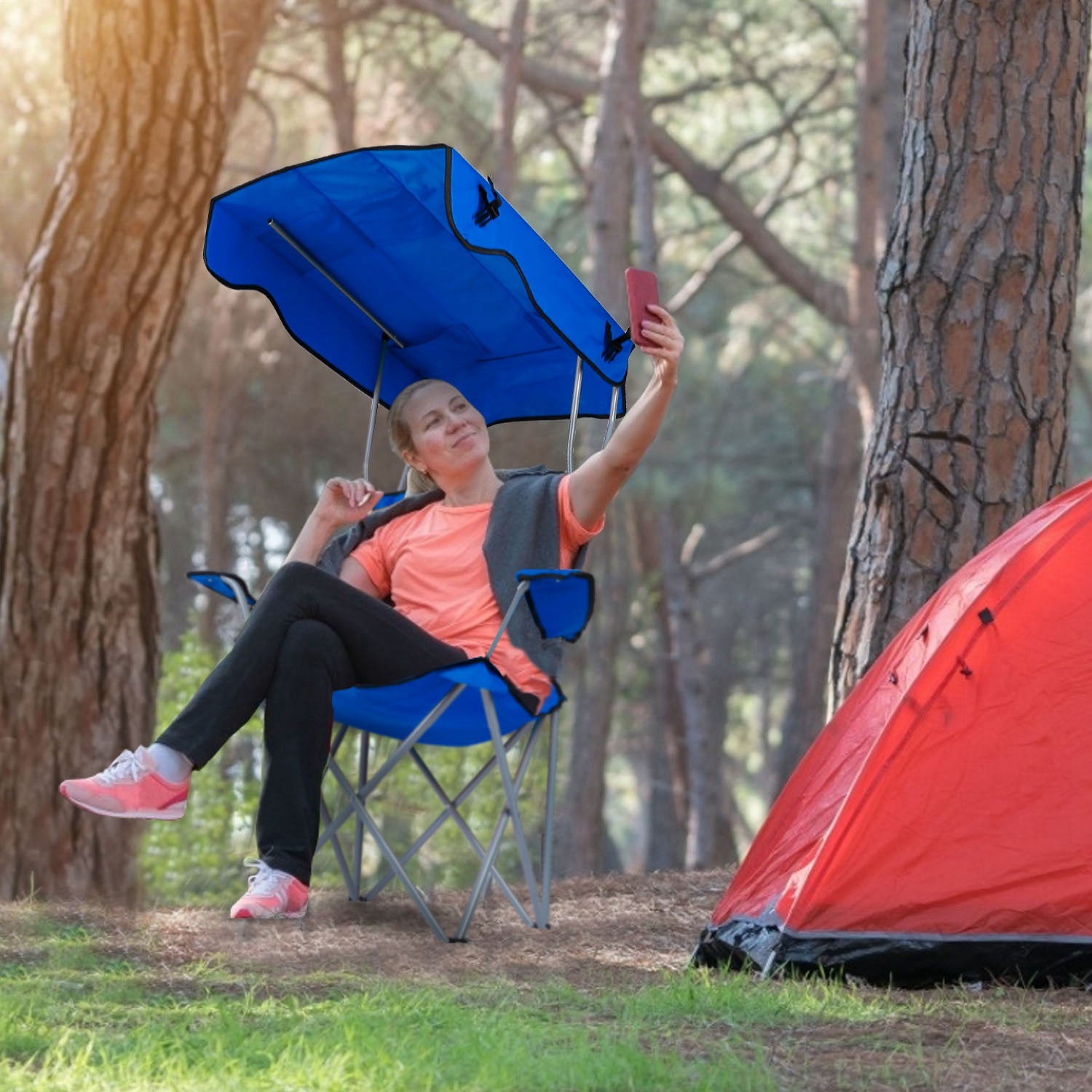 Blue foldable camping chair with canopy and padded seat on steel X-frame