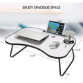 Foldable lap desk with grayish white top, black frame, and cup holder groove