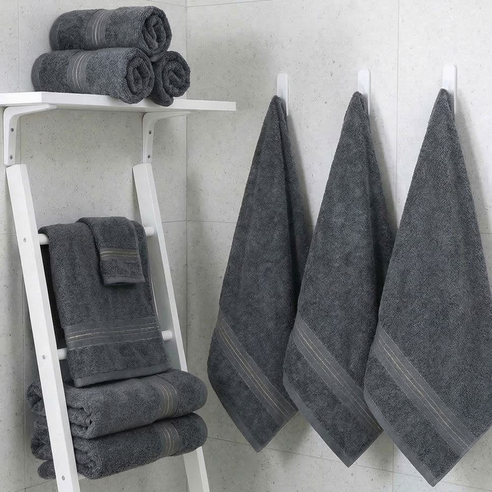 Dark gray cotton bath towel set, folded towels on shelf with additional hanging towels
