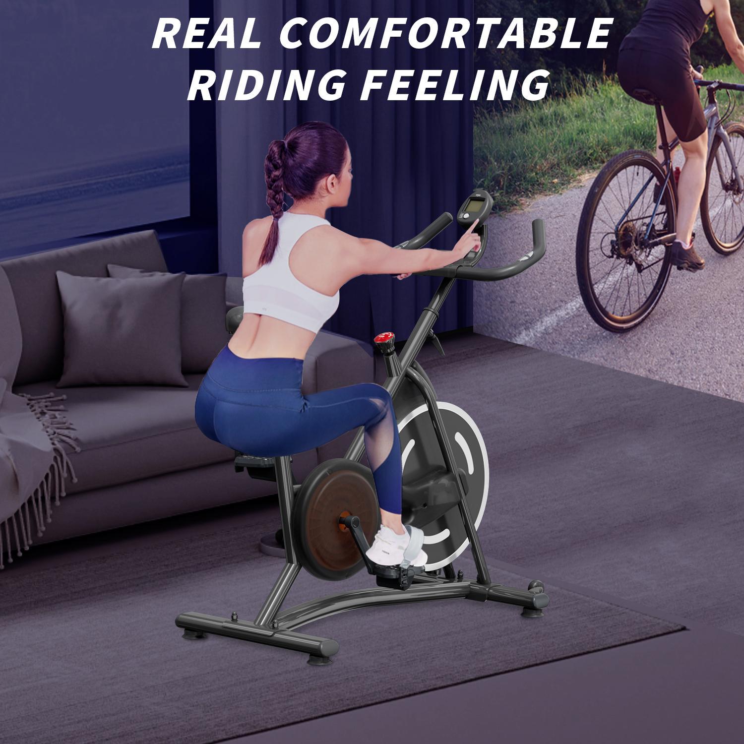 Indoor spin bike with rider seated, adjustable handlebars and tension controls
