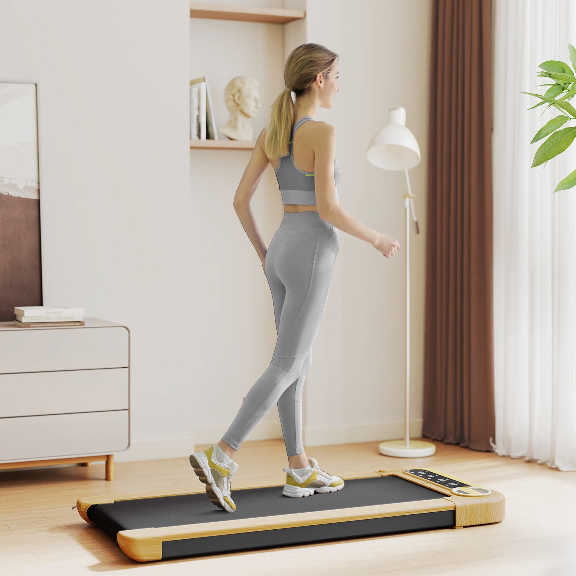 Wide under-desk walking treadmill with black belt and light wood base, in home setting