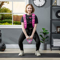 Woman wearing pink weighted training vest with black adjustable straps and front weight panel