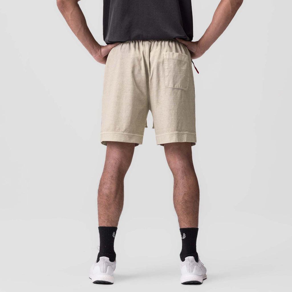 Beige shorts with elastic waistband and drawstring; straight legs and pull-on fit