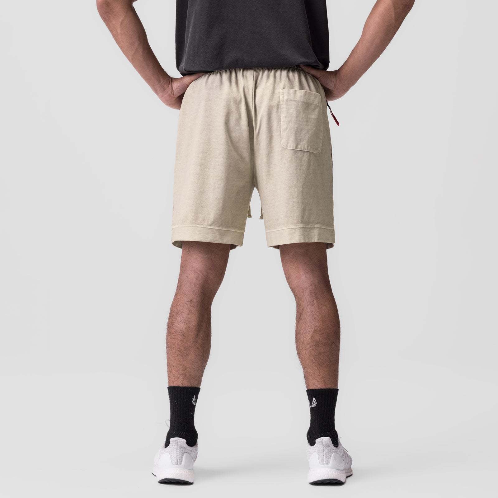 Beige shorts with elastic waistband and drawstring; straight legs and pull-on fit