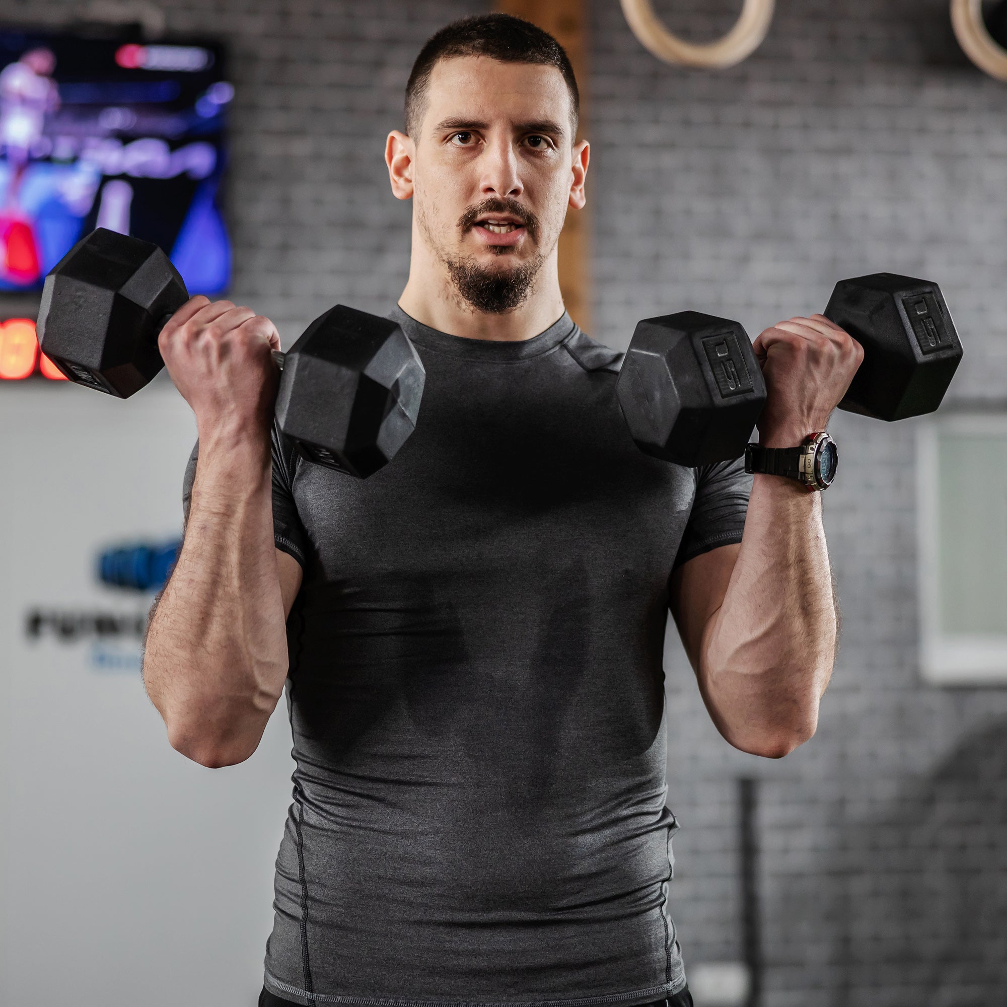Hex rubber dumbbells in black with textured grip and raised weight markings