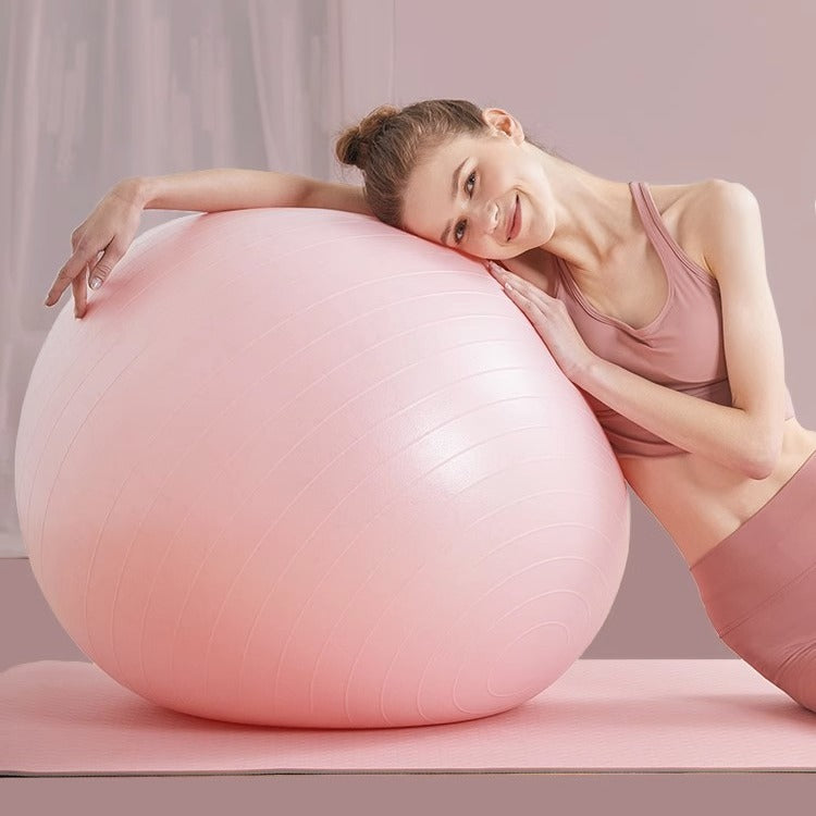 Light pink stability exercise ball with grip lines, used for core workout support