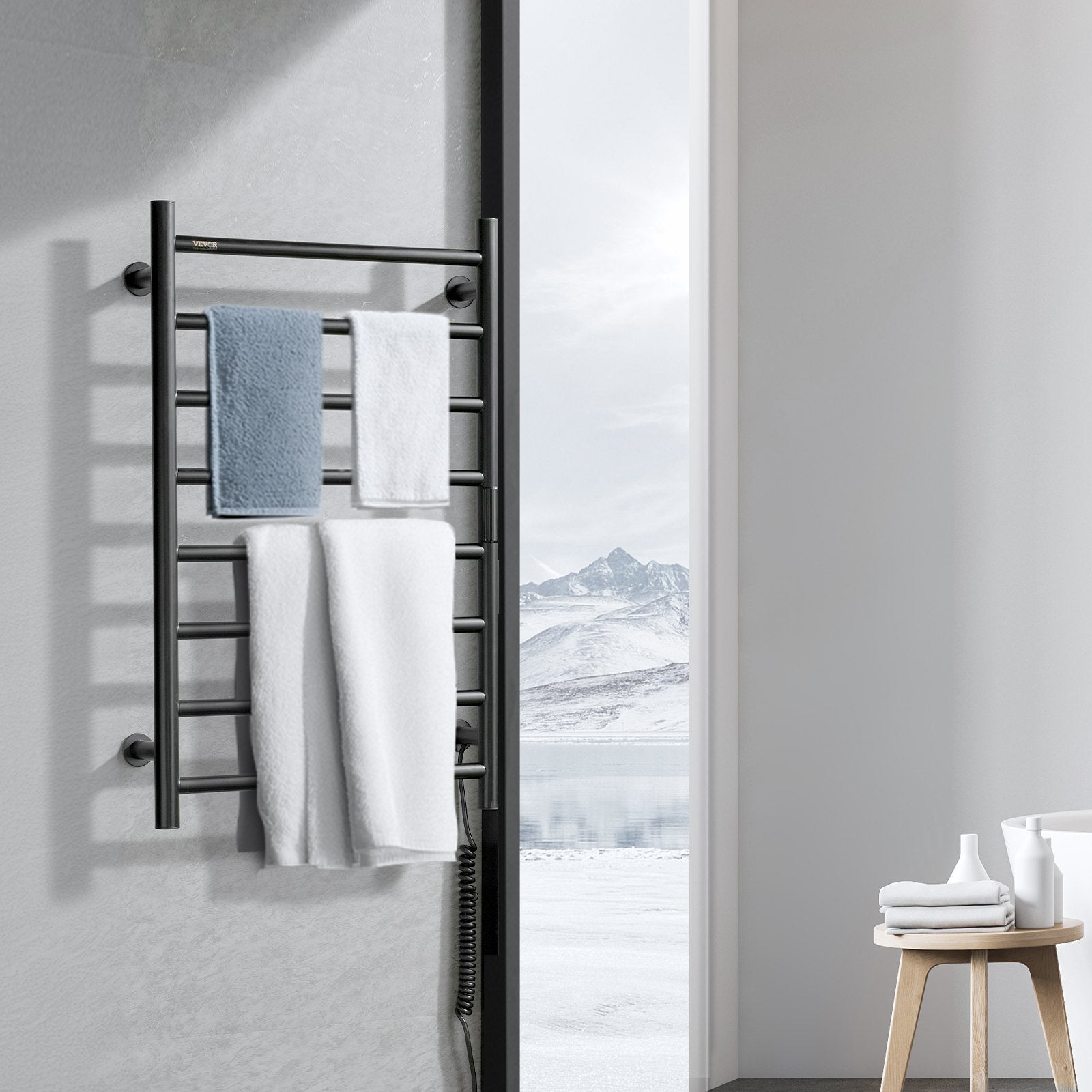 Black heated towel rack holding white and blue towels on wall-mounted bars